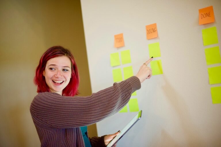 ¿Qué es la metodología Agile?, woman in gray sweater holding white and yellow sticky notes