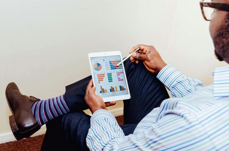 crear infografías profesionales, Businessman using a tablet for data analysis in a relaxed office setting.