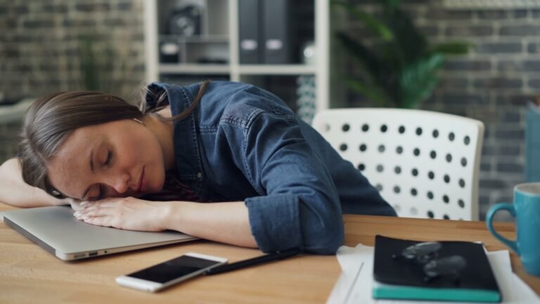 dejar de procrastinar, a woman laying her head on a laptop