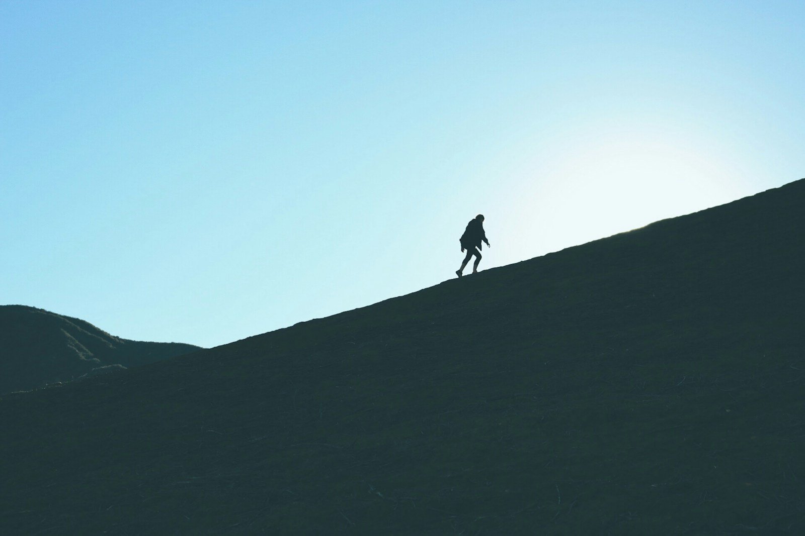 método Kaizen, silhouette of man climbing hill