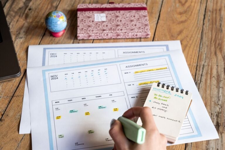 Planificación estratégica de comunicaciones, Person planning tasks with a calendar and notepad on a wooden table.