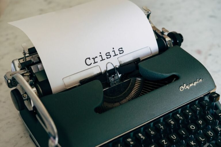 manejo de crisis, Close-up of a vintage typewriter with the word 'Crisis' typed on paper.