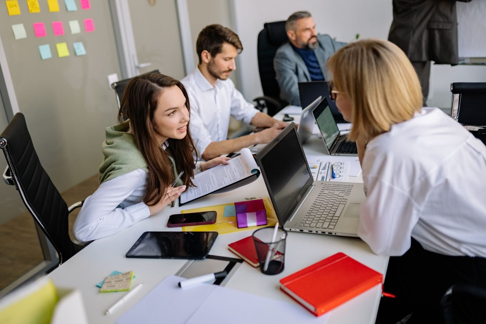 escucha activa en las empresas, Team discussion in a modern office setting, focusing on cooperation and strategy development.