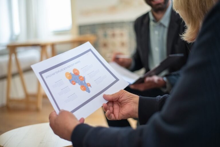mapa de públicos, Three professionals discussing a data presentation in an office setting.