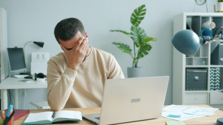 cómo prevenir una crisis, Man rubbing his face in front of laptop
