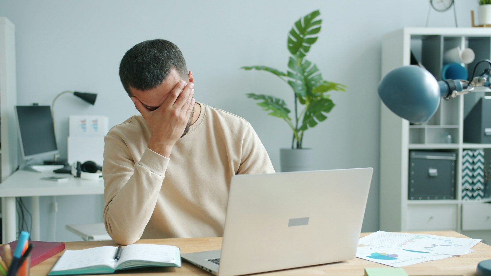 cómo prevenir una crisis, Man rubbing his face in front of laptop