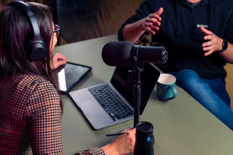 herramientas para crear un podcast, a person with headphones on using a laptop